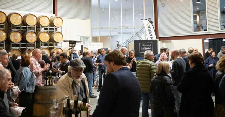 group of people gather in Zema Estate's barrel room for a back vintage tasting