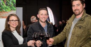 three happy people drink red wine at the coonawarra roadshow