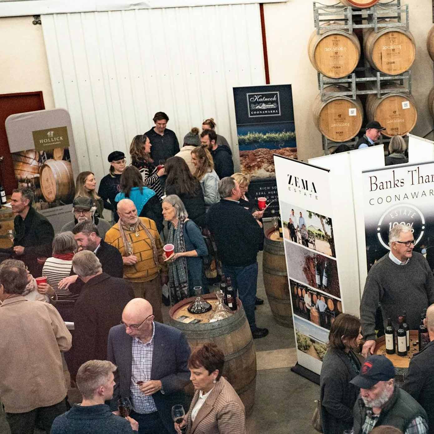 Coonawarra vignerons and people gather around a hall and drink wine