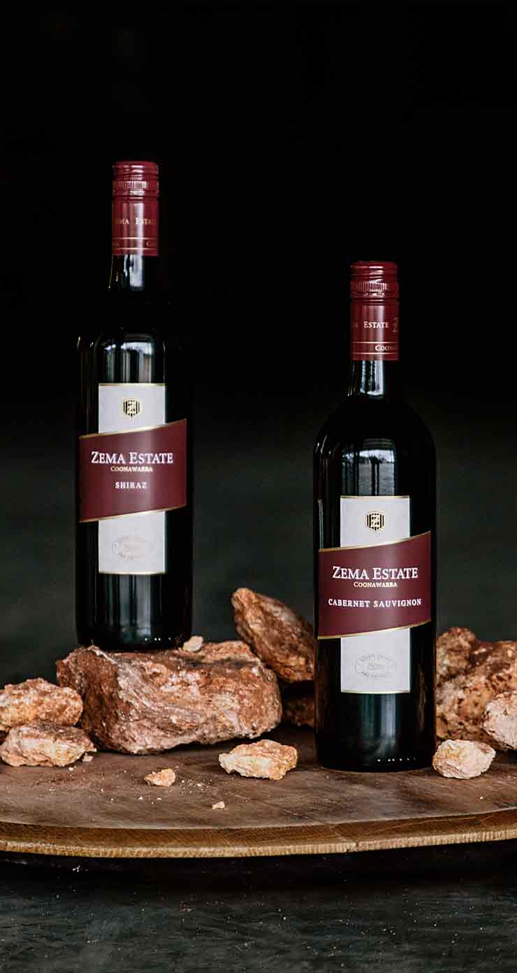 two bottles of estate range cabernet and shiraz sitting on limestone coast rocks