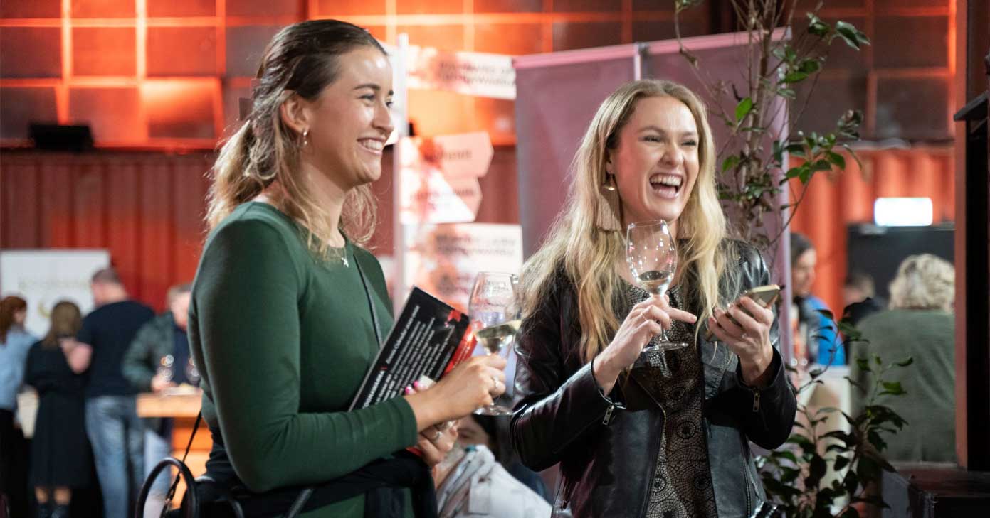 two young girls laugh as they enjoy red wine at the coonawarra roadshow