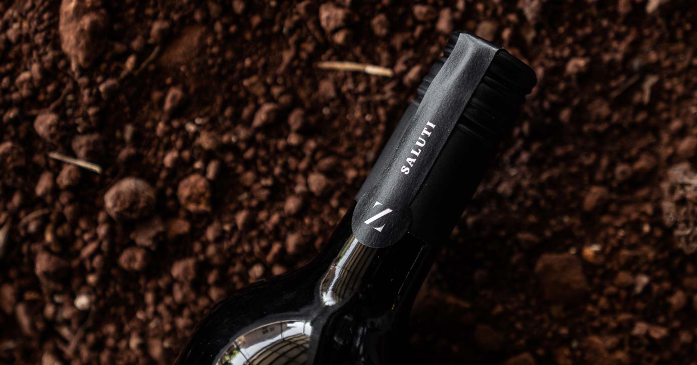 a bottle of saluti on terra rossa red soil