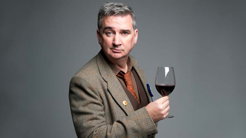 Damian Callinan holds glass of red wine