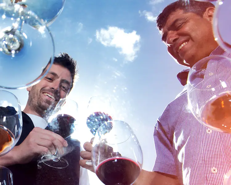 Lewis White and Nick Zema share a glass of wine, shot under glass