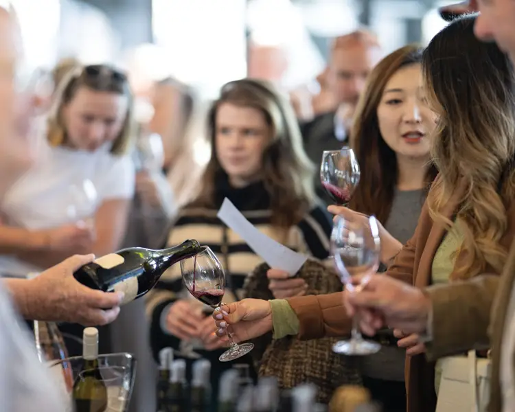 large crowd enjoy wine being poured at tasting event
