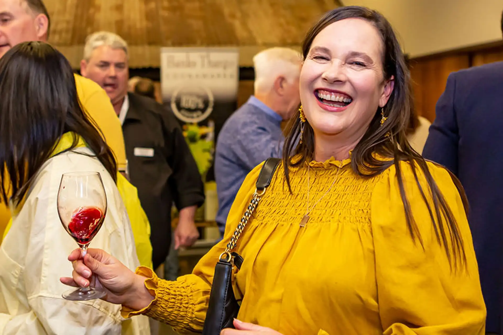 Lady in yellow top swirls glass of coonawarra cabernet
