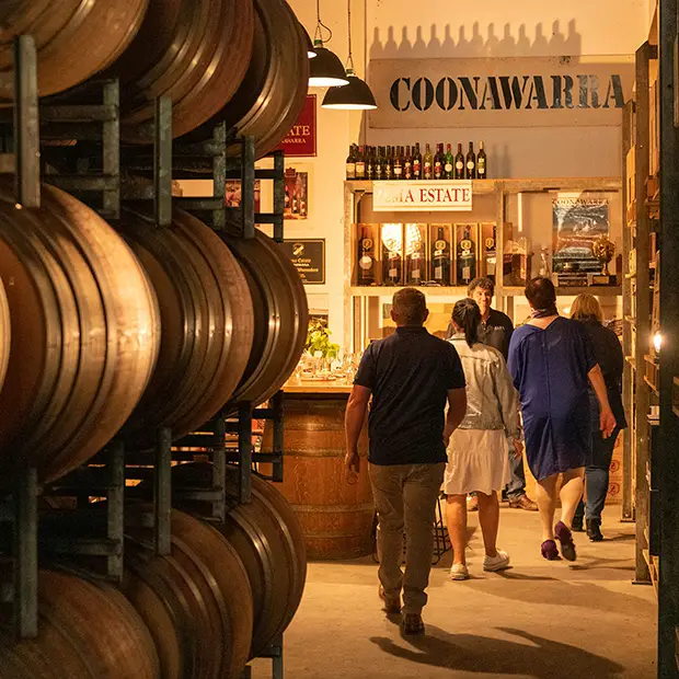 people walk down barrels to hidden winery museum area